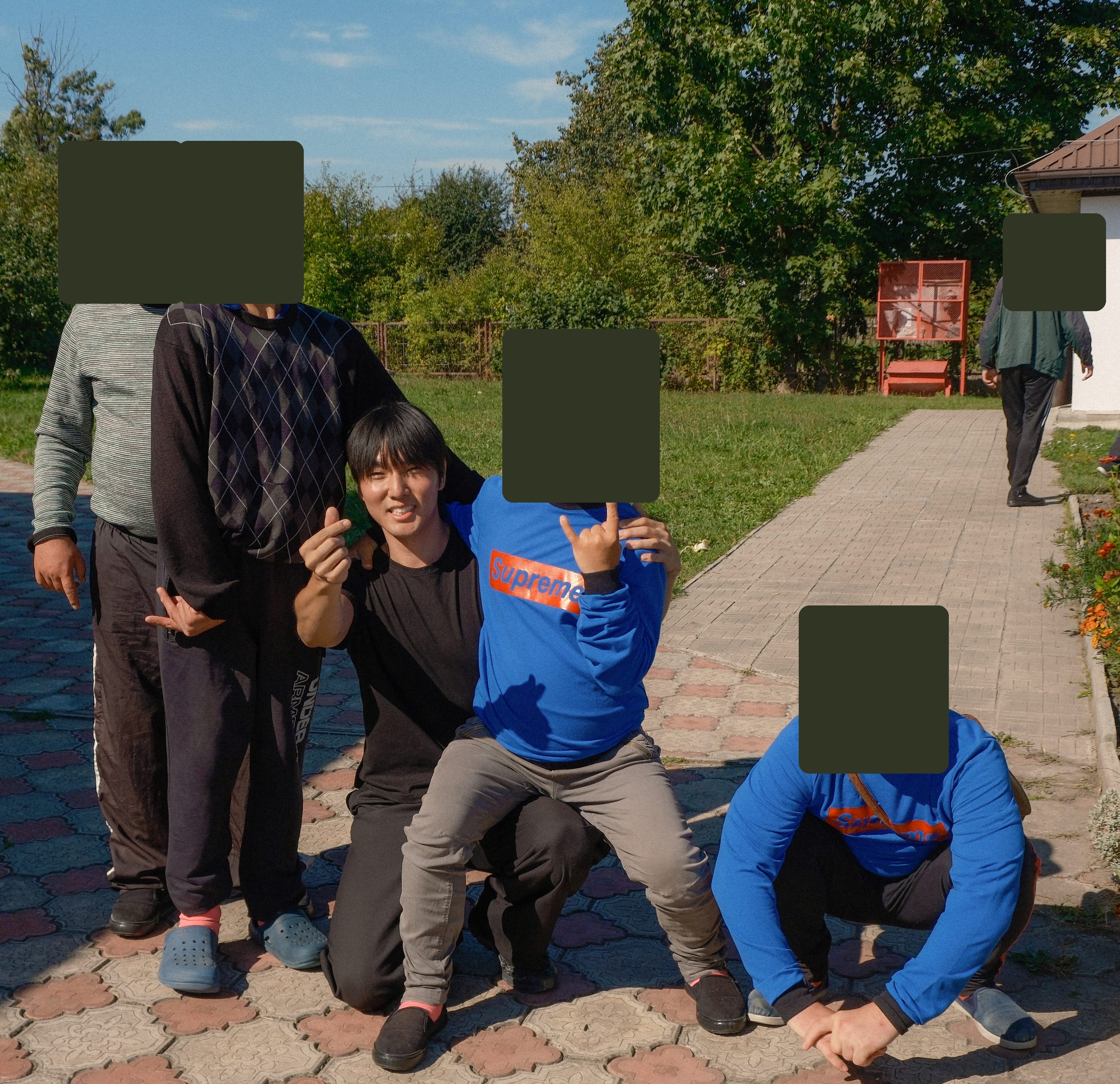 Opening photo of the latest story (phone: a film photo of rail lines; desktop: Daniel kneeling with friends outside a care home; other faces covered)
